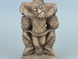 une petite statue représentant un homme tenant un enfant dans ses bras
