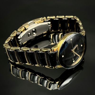 une montre noire et dorée posée sur une surface noire