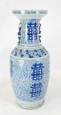 un vase bleu et blanc posé sur une surface blanche