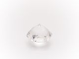 a close up of a clear diamond on a white surface