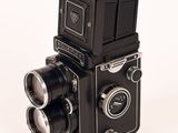 a black camera with two lenses on a white background