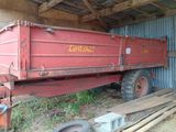 un camion-benne rouge garé dans un hangar