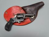 a small revolver on a leather case with a black handle