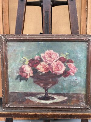 un tableau représentant des roses dans un vase posé sur un chevalet
