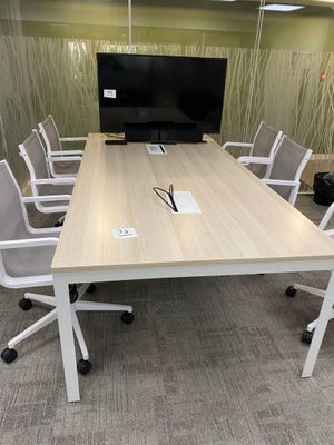 tables and chairs in a conference room with a flat screen tv on the wall