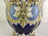 a blue and gold vase sitting on a white table