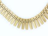 a close up of a gold necklace on a white background