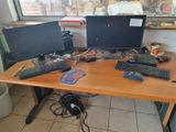a desk with two computers and a keyboard on it