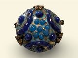 blue and gold bead on a white surface with a white background