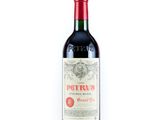 une bouteille de vin rouge posée sur une table blanche