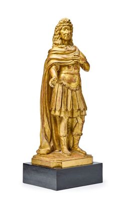 statue en or représentant un homme coiffé d'un chapeau et vêtu d'une cape, posée sur un socle en marbre