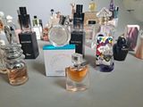 many different perfumes on a table with a mirror in the background
