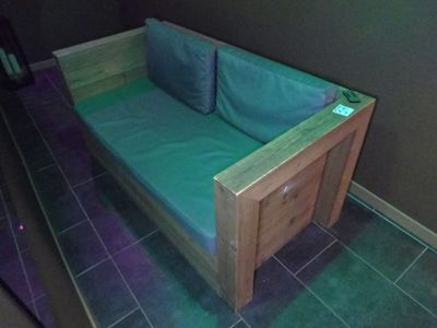 un canapé en bois recouvert d'un revêtement vert
