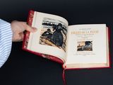 une personne tenant un livre ouvert sur lequel figure une image