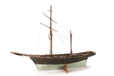 a small wooden boat that is on display on a white surface