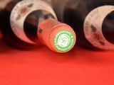 several bottles of wine are lined up on a red surface