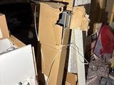 a pile of boxes and a refrigerator in the corner of a room