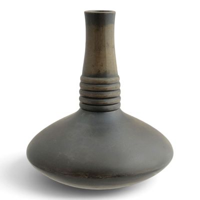 a black vase that is sitting on a white surface