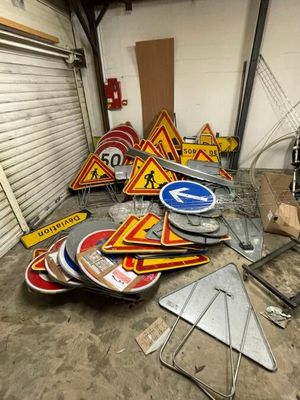 a lot of road signs that are sitting on the floor