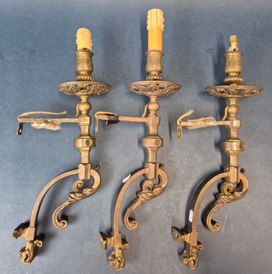 Suite de trois appliques en métal doré à décor d'enroulement…
