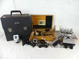 a box with a camera, a camera case, and other items on a white surface