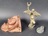 a small statue of an angel next to a small statue of an angel