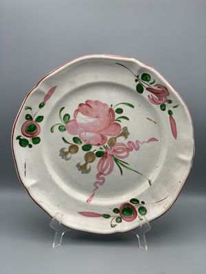 une assiette blanche ornée d'une fleur rose