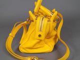 a yellow purse with a zipper on the front and a strap around it