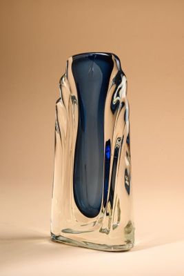 un vase en verre posé sur une table, sur fond marron