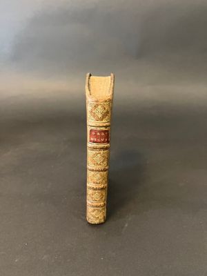 an old book sitting on top of a table next to a gray wall