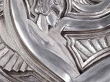 a silver sculpture of a woman holding a plate
