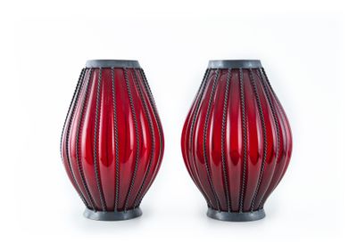 pair of red glass vases with black bases on a white background