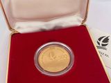 l'image d'une pièce d'or dans un écrin rouge posé sur un fond blanc