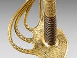 a gold plated sword with an elaborate handle