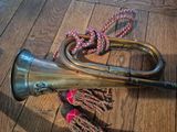 a brass trumpet and a rope on a wooden floor