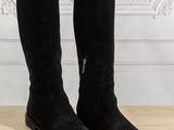 a pair of black boots sitting on top of a wooden floor