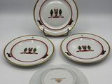 three plates and a bowl with a bird on them