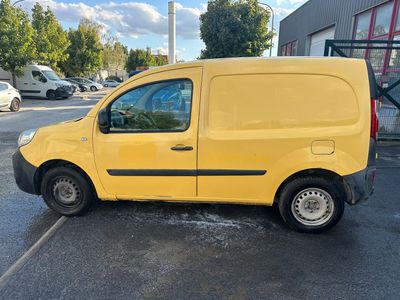 the yellow van is parked in the parking lot next to the building