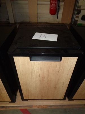 a small black dishwasher sitting on top of a wooden counter