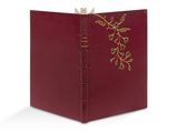 un livre rouge dont la couverture est ornée d'une décoration en feuille d'or