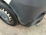 a close up of a car ' s front tire with a denting on it