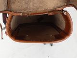a brown leather bag with a handle on a white surface