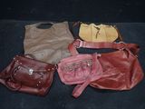 four purses are lined up in a row on a black surface