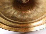 a close up of a brass plate with a candle on it