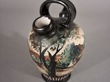 a vase with a painting on it sitting on a table