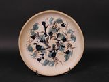 une assiette ornée d'un motif représentant des fleurs et des oiseaux