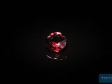 un diamant rouge sur une surface noire