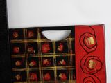 a red and black bag with gold designs on it