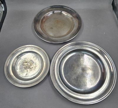 three silver plates sitting on top of each other on a stove