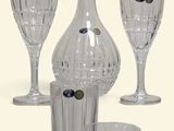 four glasses and a decanter sitting on a table